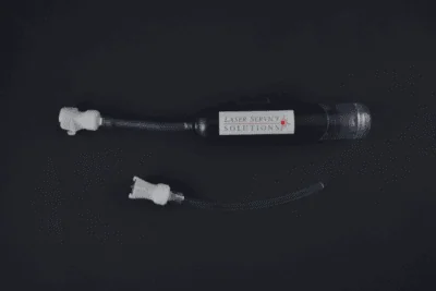 A Handpiece Drain Pump Kit—a black device labeled Laser Service Solutions with an attached hose and white connector, plus a separate hose and connector—displayed on a dark background.