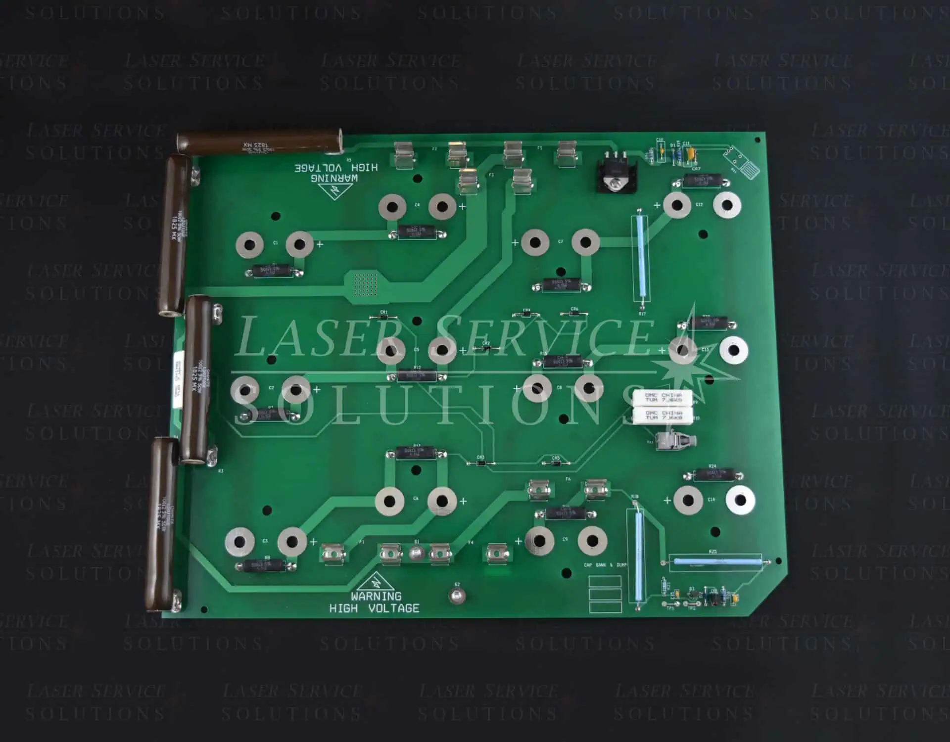 The Elite Cap Bank Dump Board is a green printed circuit board featuring multiple metal connectors, components, and labeled sections. It is shown against a dark background and includes a warning label indicating high voltage.