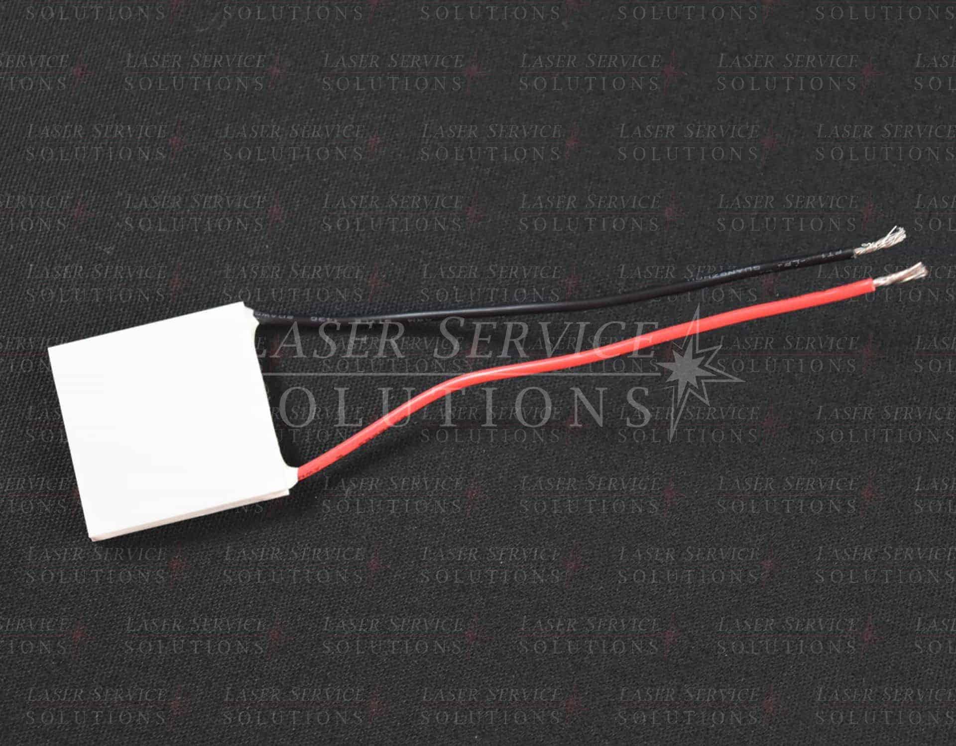 A Soprano XL Thermo Electric Cooler (TEC), a white rectangular electronic component with red and black wires attached, is set on a dark background featuring Laser Service Solutions watermarks.