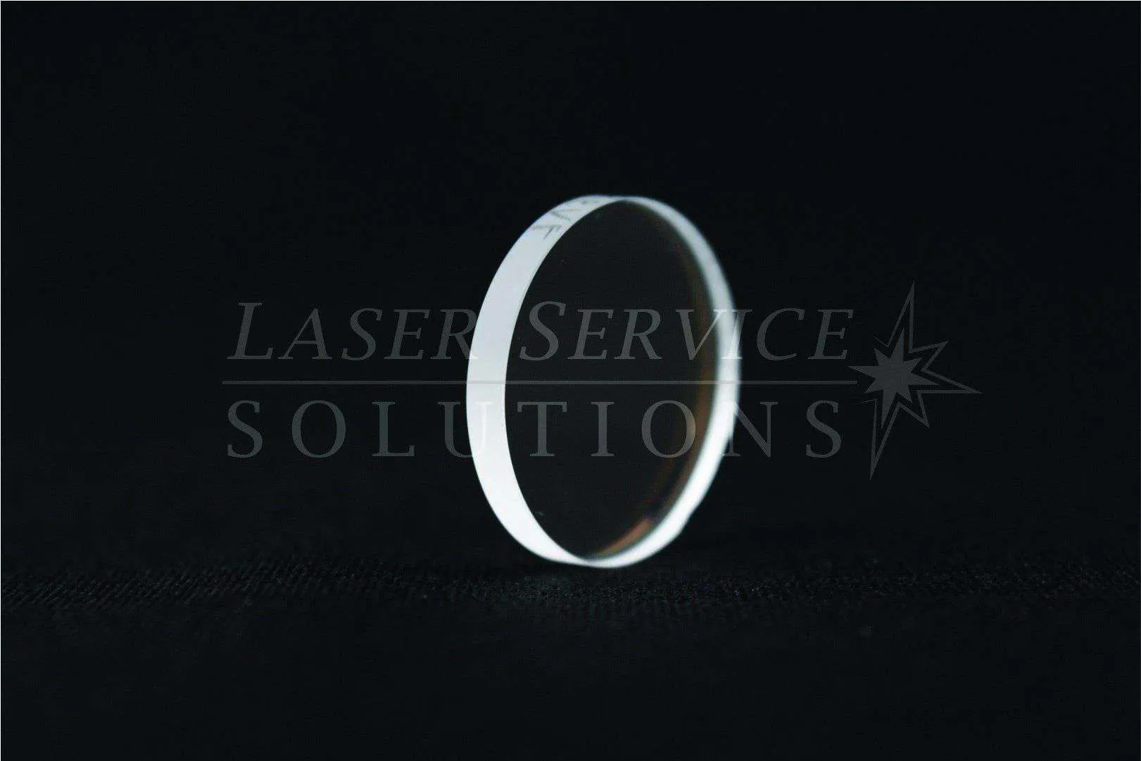 A HOYA ConBio SHG Input Window, featuring a clear and circular optical lens, is displayed upright on a dark surface with the Laser Service Solutions watermark faintly visible in the background.