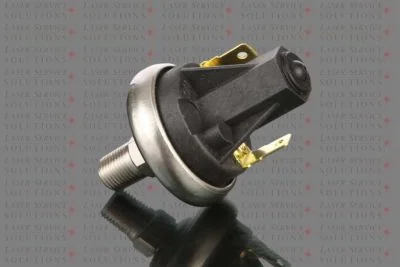 A close-up of the Elite Coolant Pressure Switch, a black and silver sensor with two gold connectors, placed on a reflective surface. The background features repeating text: LASER SERVICE SOLUTIONS.