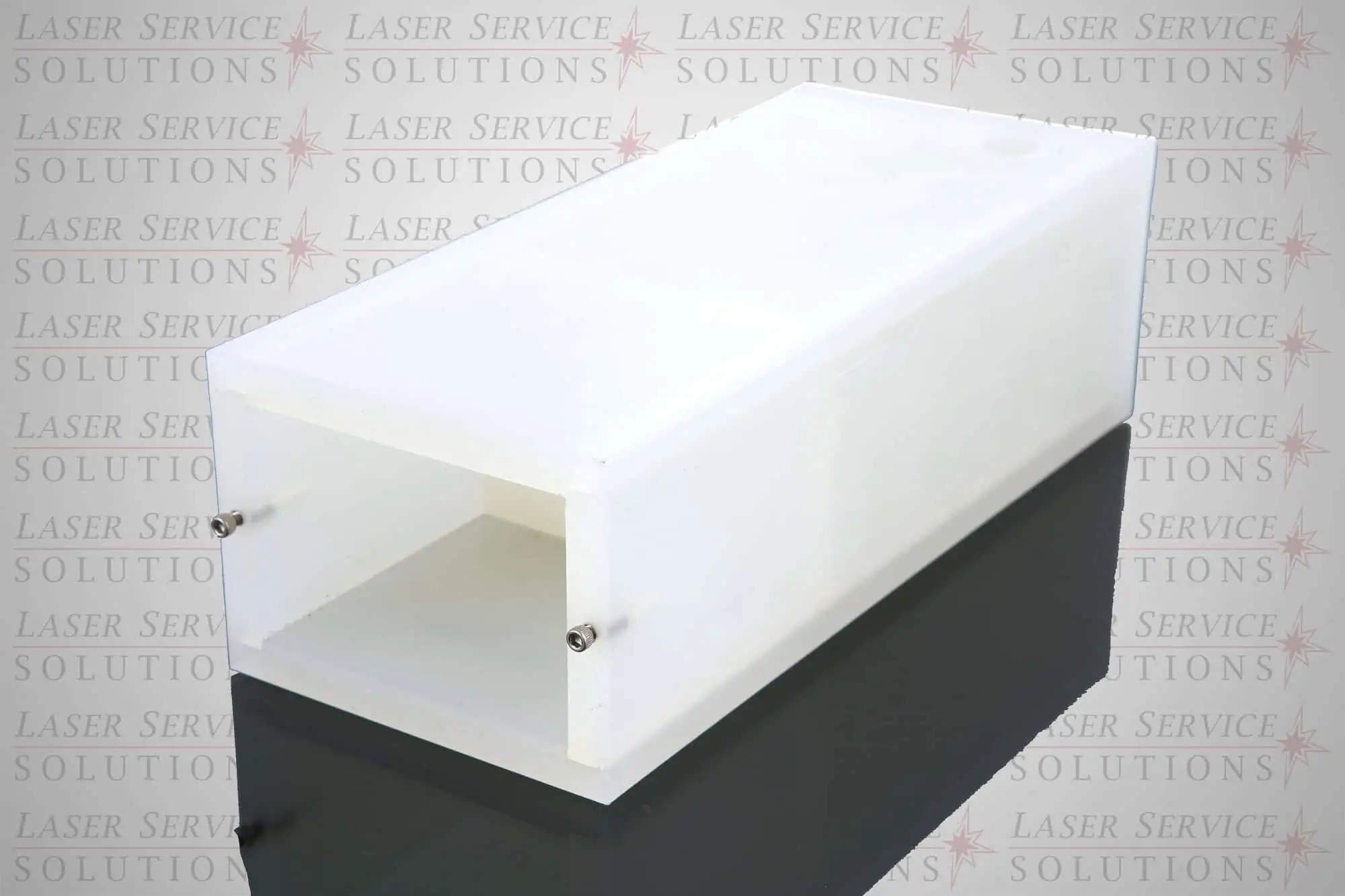 A white rectangular plastic Elite Coolant Reservoir with an open front, two metal screws on the side, and a reflective black surface beneath. The background faintly features the Laser Service Solutions logo repeated.