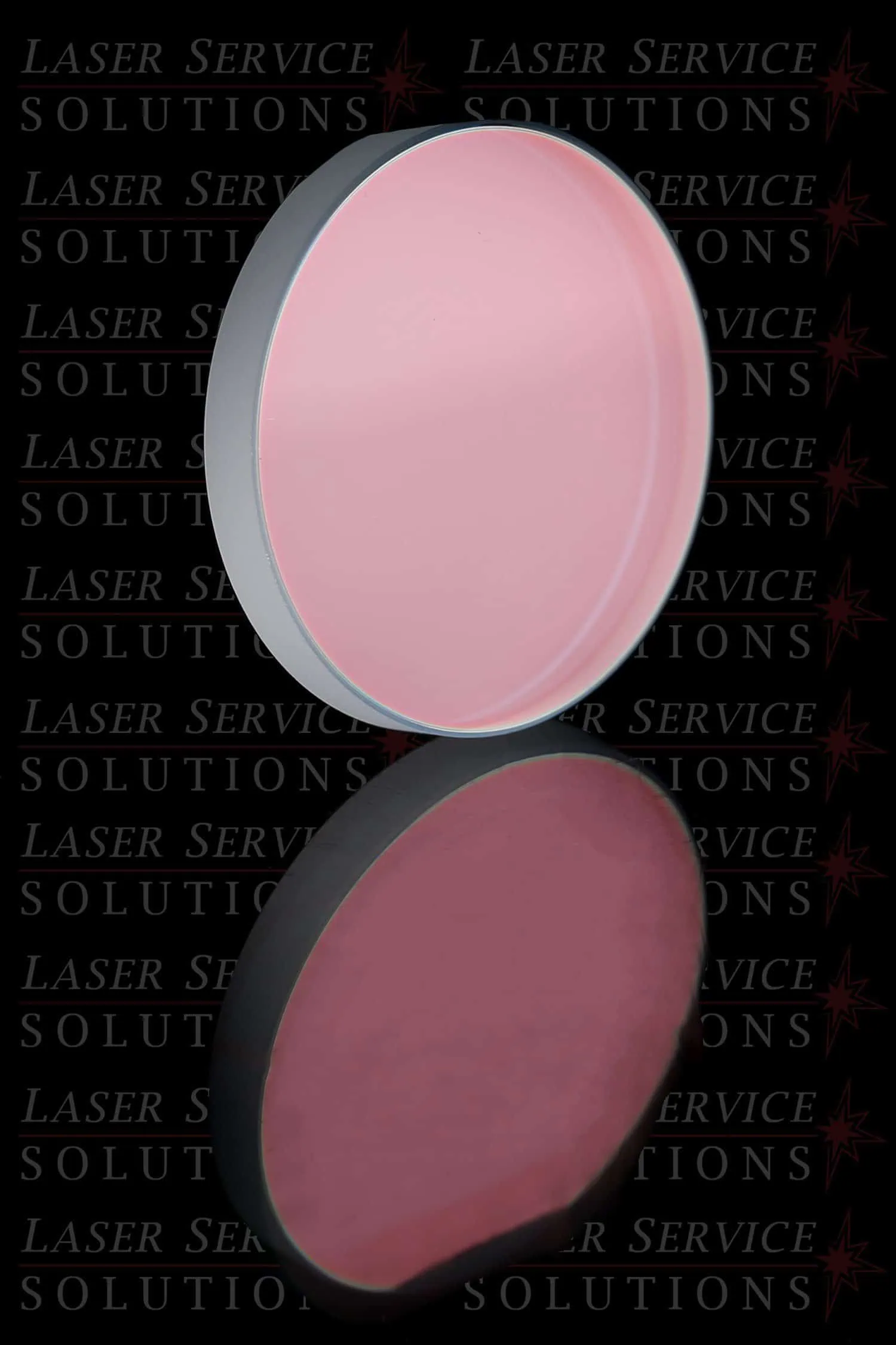 A round Elite Yag Turning Mirror with a pink tint is displayed on a reflective surface, set against a black background repeatedly printed with the Laser Service Solutions logo.
