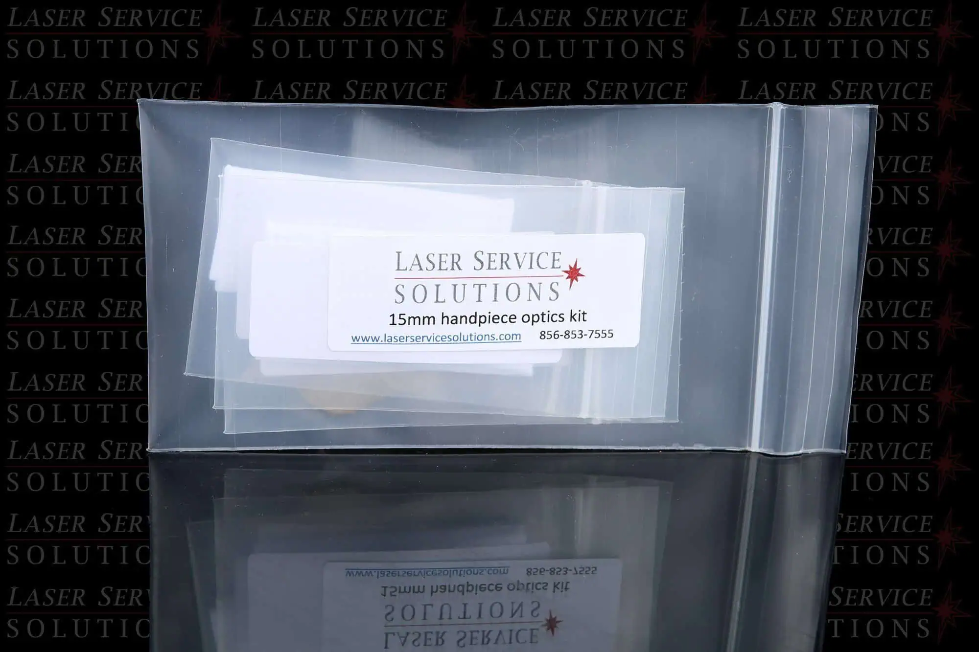A clear plastic bag labeled Elite Handpiece Optics Kit with contact details, set against a background with repeated Laser Service Solutions branding.